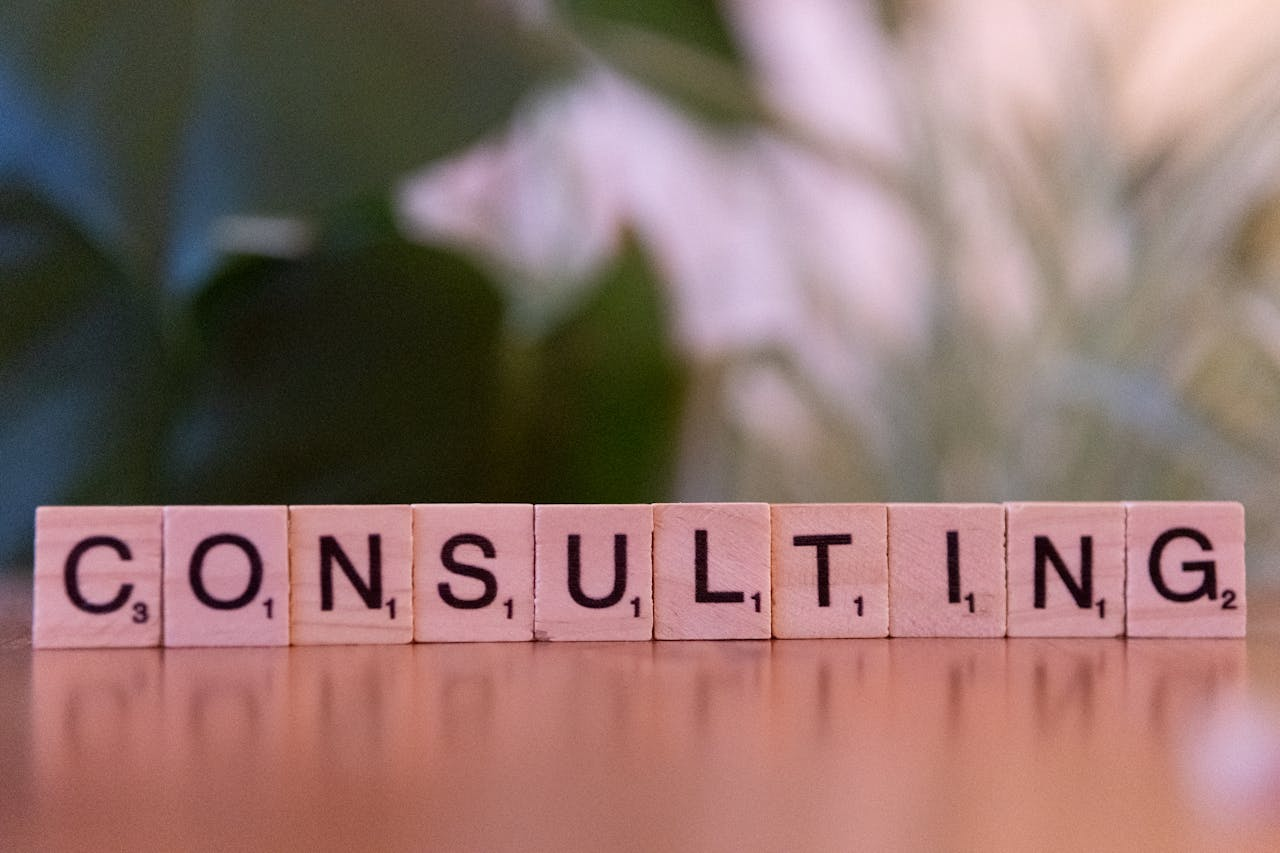 creative-03 Wooden letter tiles spelling 'Consulting' with a blurred background. Ideal for business concepts.