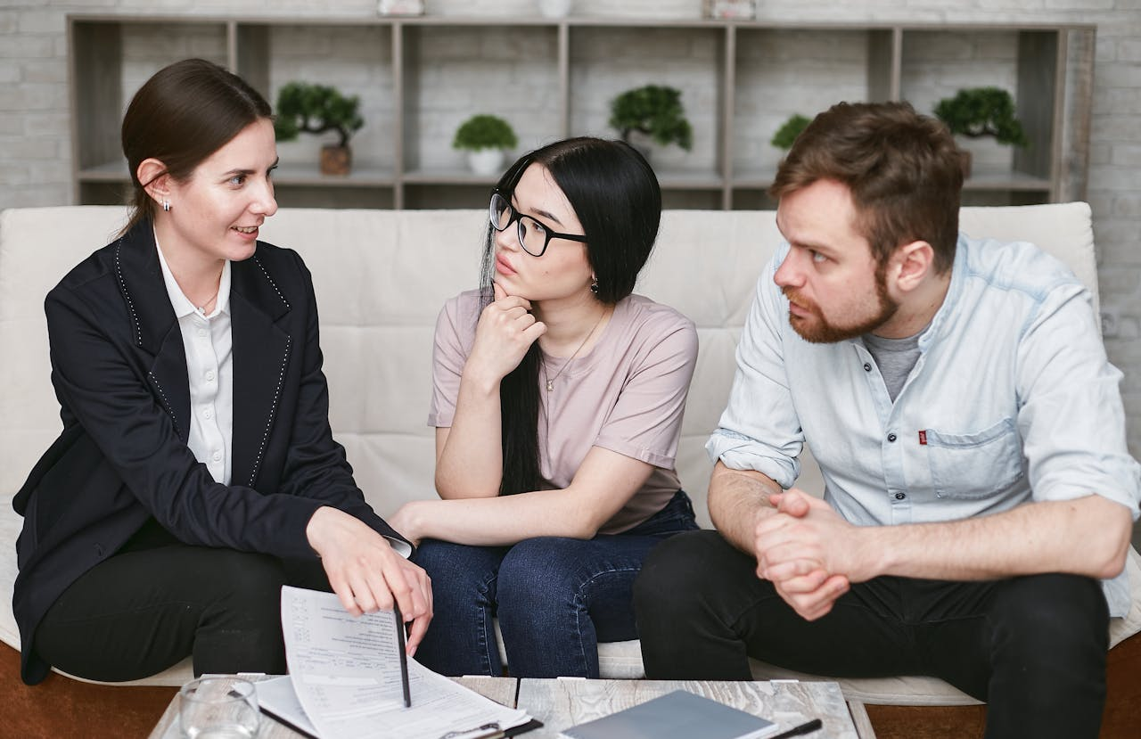 why-choose-us Three adults discussing business inside, focused on cooperation and strategy.