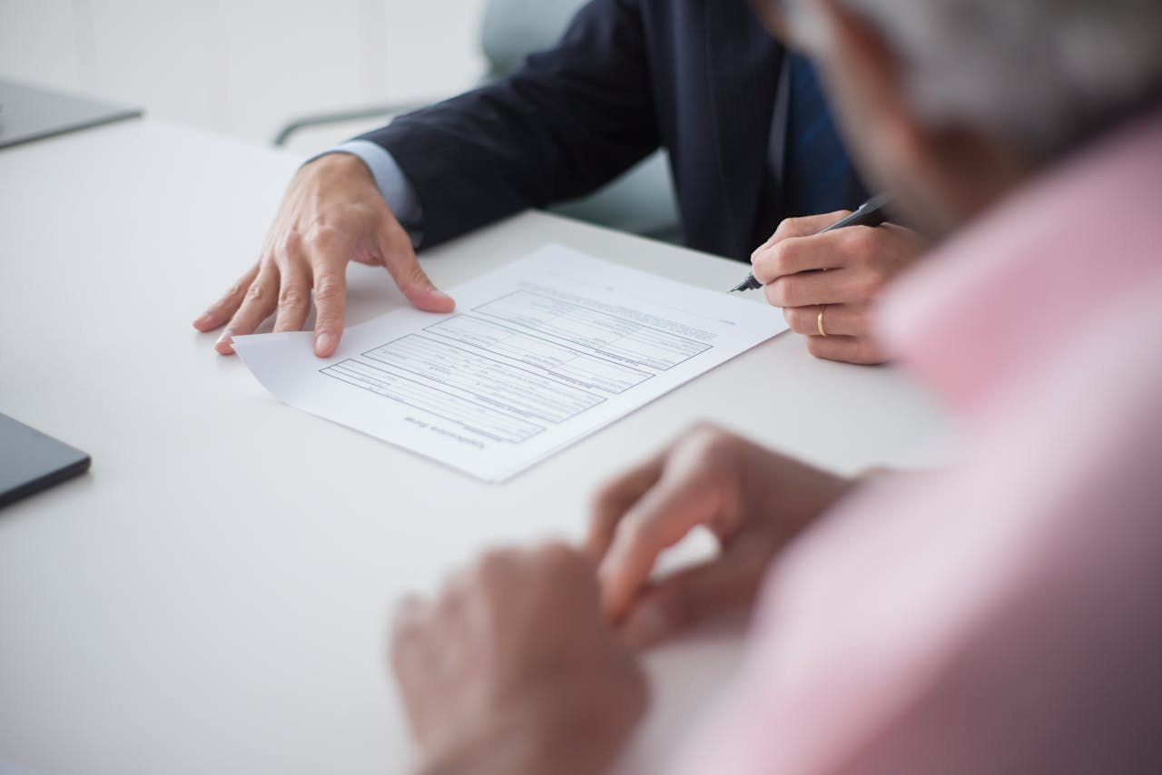 Services-03 Two professionals engaging in a business meeting, signing documents for a consulting agreement.
