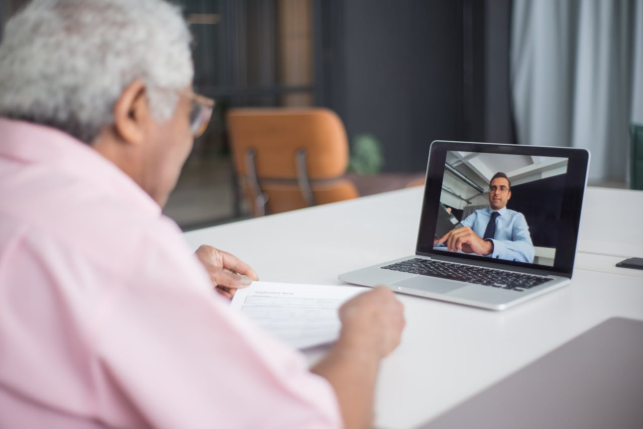Services-02 Senior discussing business on a video call with a consultant on a laptop.